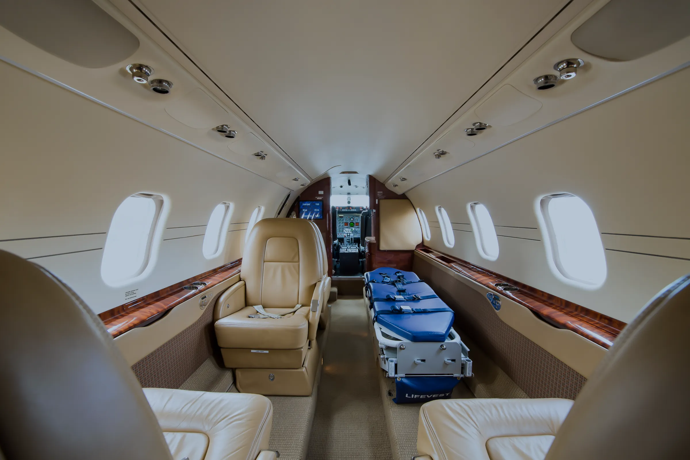 The Learjet cabin set as a flying ICU: a stretcher with blue mattress beside leather seats. (their own photograph)