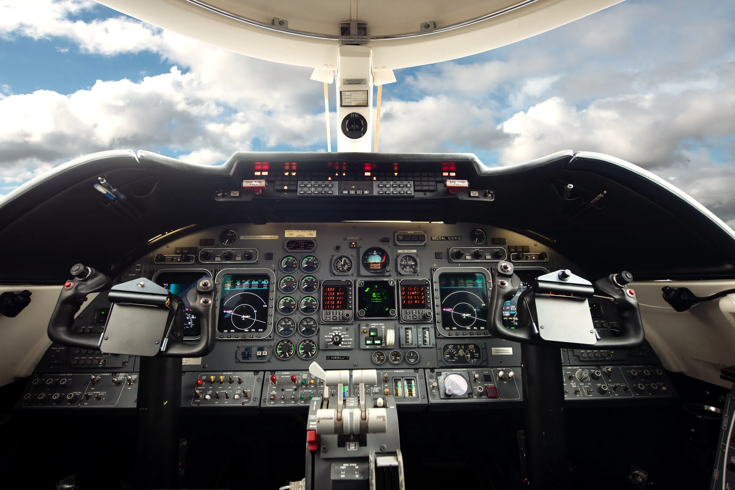 The Learjet cockpit, instrument panel and controls, clouds through the windscreen. (their own photograph)