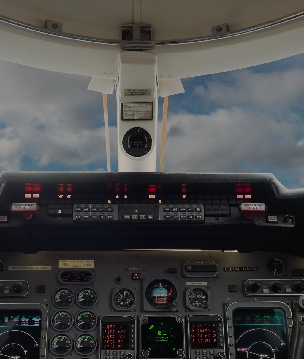 The Learjet cockpit: the windscreen, clouds beyond, and the glareshield above the instrument panel. (their own photograph)